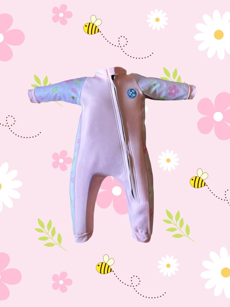 An image of the Bubble Tots Easy Zip Thermal Swimsuit in Pink Flowers and Bees Spring design. The design features playful Bees and Flowers. The background colour is a soothing neutral pink tone with pops of vibrant Flowers and Bees illustrations