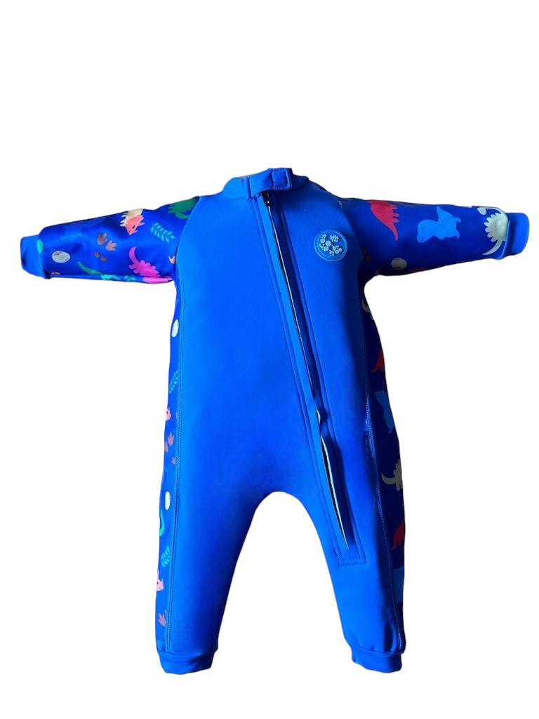 An image of the Bubble Tots Easy Zip Thermal Swimsuit in Blue Dinosaur design. The design features playful Dinosaurs and Eggs. The background colour is a bright vibrant tone with pops of vibrant Dinosaur illustrations